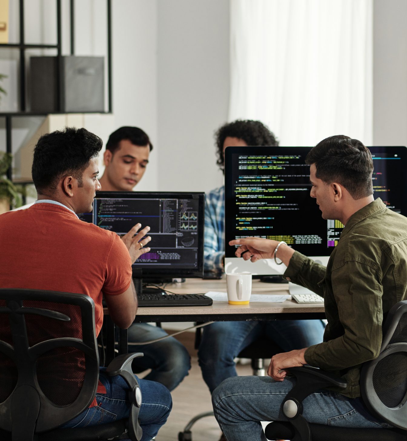 Our product team collaborating around monitors full of code